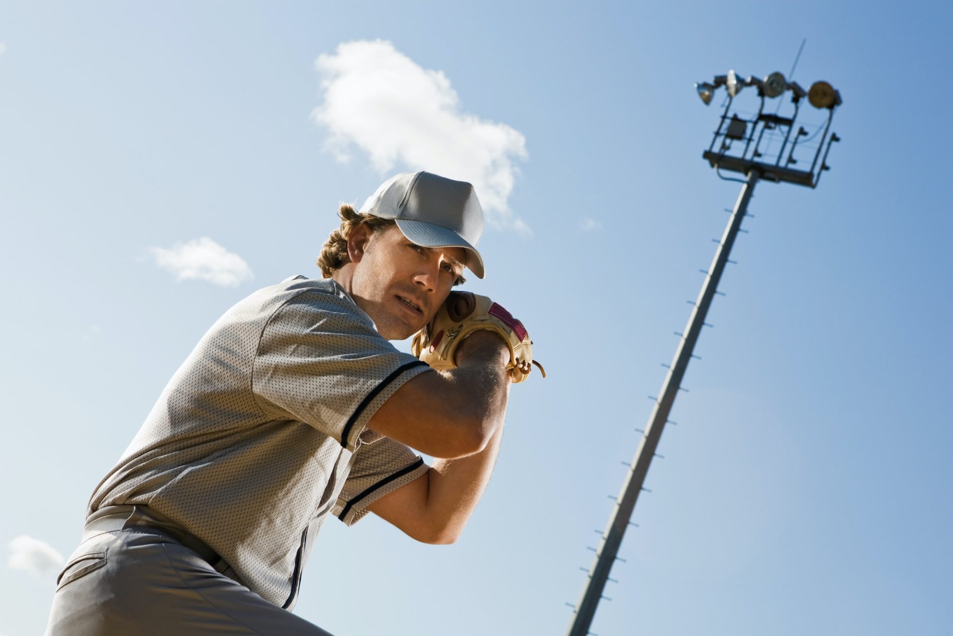 Baseball player preparing to swing under bright stadium lights, highlighting the need for skilled umpires and professional officiating programs in Missouri and Arkansas.